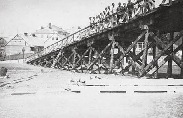 Maj 1941 r. Fotografia ukazująca niemiecką odbudowy mostu na Rospudzie, wysadzonego w 1939 roku przez żołnierzy Straży Granicznej por. Piotra Łazarewicza. Zdjęcie wykonano na rynku w Filipowie, w tle widoczny Dom Parafialny. Maj 1941 r. Fotografia ukazująca niemiecką odbudowy mostu na Rospudzie, wysadzonego w 1939 roku przez żołnierzy Straży Granicznej por. Piotra Łazarewicza. Zdjęcie wykonano na rynku w Filipowie, w tle widoczny Dom Parafialny.