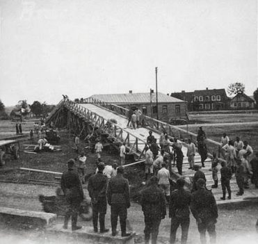 Maj 1941 r. Fotografia ukazująca niemiecką odbudowy mostu na Rospudzie, wysadzonego w 1939 roku przez żołnierzy Straży Granicznej por. Piotra Łazarewicza. Zdjęcie wykonano na rynku w Filipowie, w tle widoczna remiza strażacka na rynku w Filipowie. Maj 1941 r. Fotografia ukazująca niemiecką odbudowy mostu na Rospudzie, wysadzonego w 1939 roku przez żołnierzy Straży Granicznej por. Piotra Łazarewicza. Zdjęcie wykonano na rynku w Filipowie, w tle widoczna remiza strażacka na rynku w Filipowie.